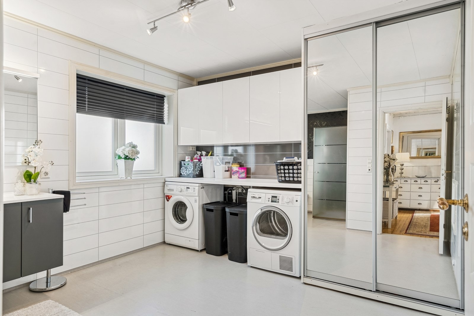 Vaskeavdeling med arbeidsbenk, overskap og opplegg for vaskemaskin. Skyvedørsgarderobe med installert 300 liters v.v.bereder og ekstra sluk i gulv. Galleribilde