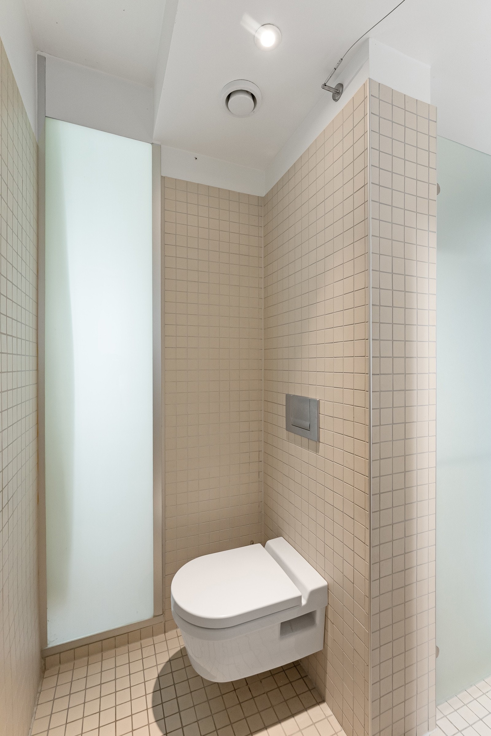 Veggmontert klosett med frostet glassfelt på allrommet. Galleribilde