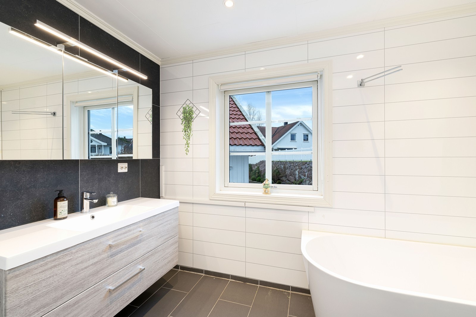 Bad innredet med badekar, servant, speilskap og wc. Galleribilde