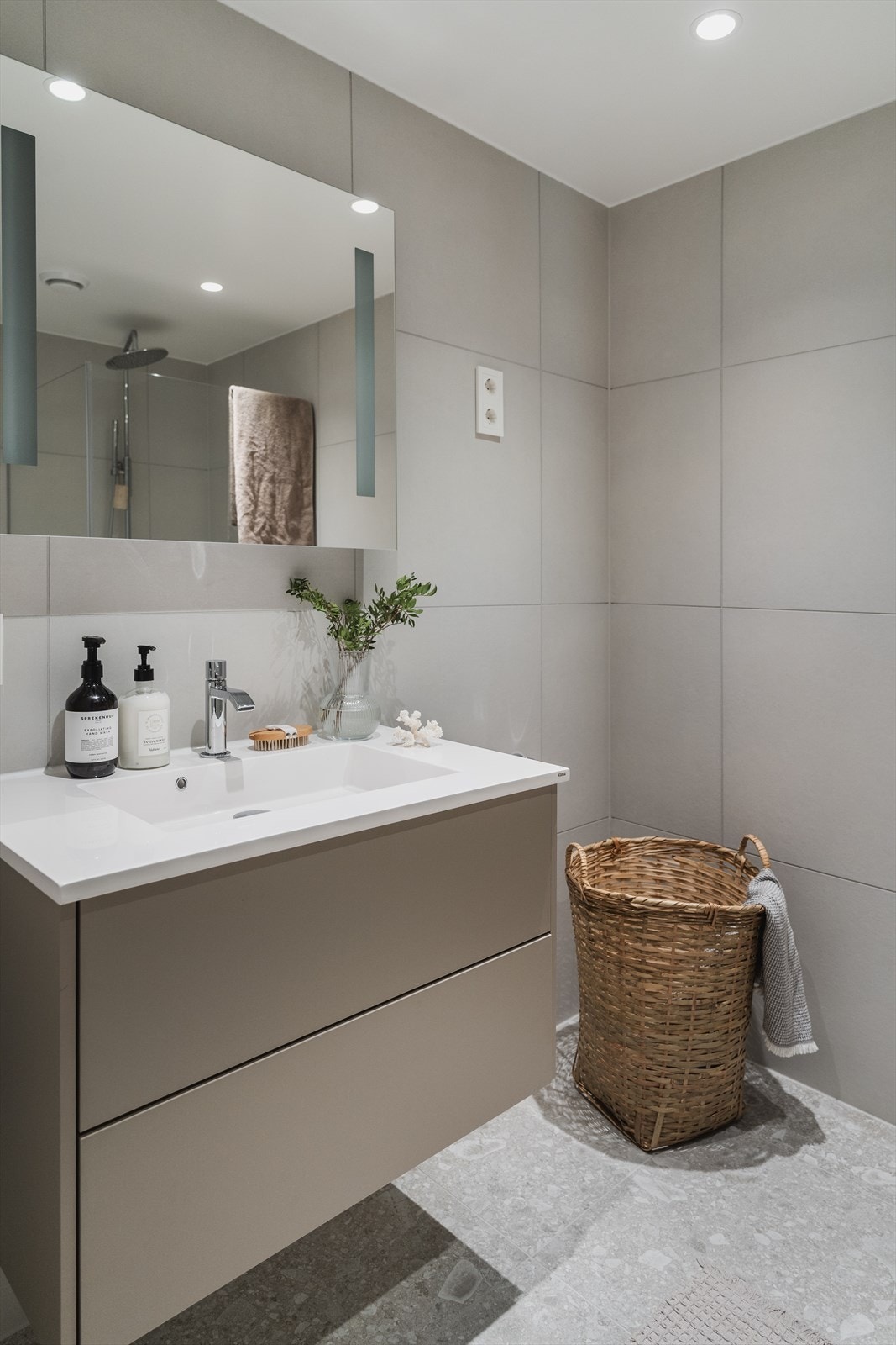 Speilet over vasken er tilpasset bredden på innredningen, hvilket tilfører en ren og harmonisk finish Galleribilde