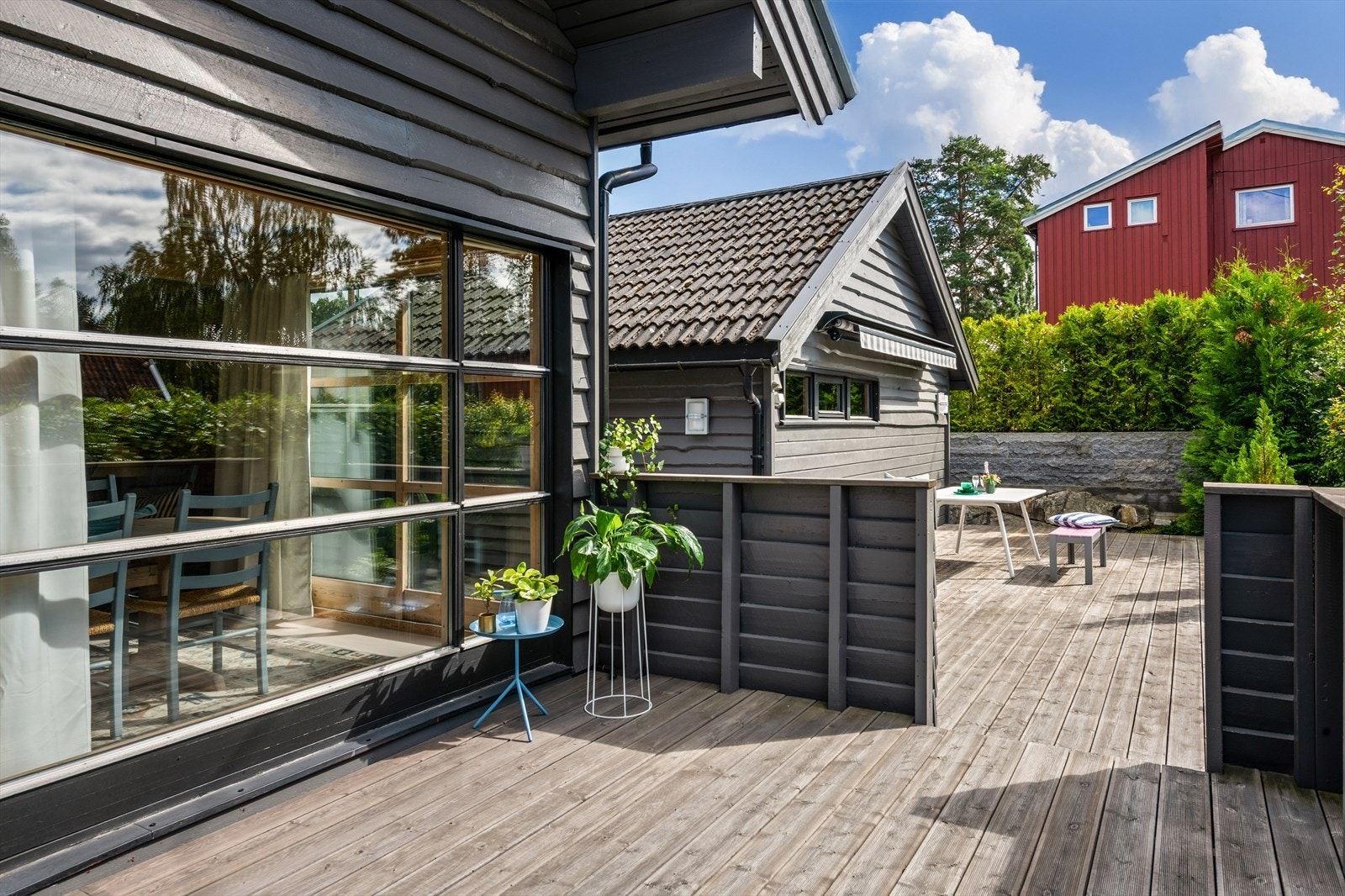 Bred skyvedør ut til veranda gjør uteplassen til en fin forlengelse av stuen om sommeren Galleribilde