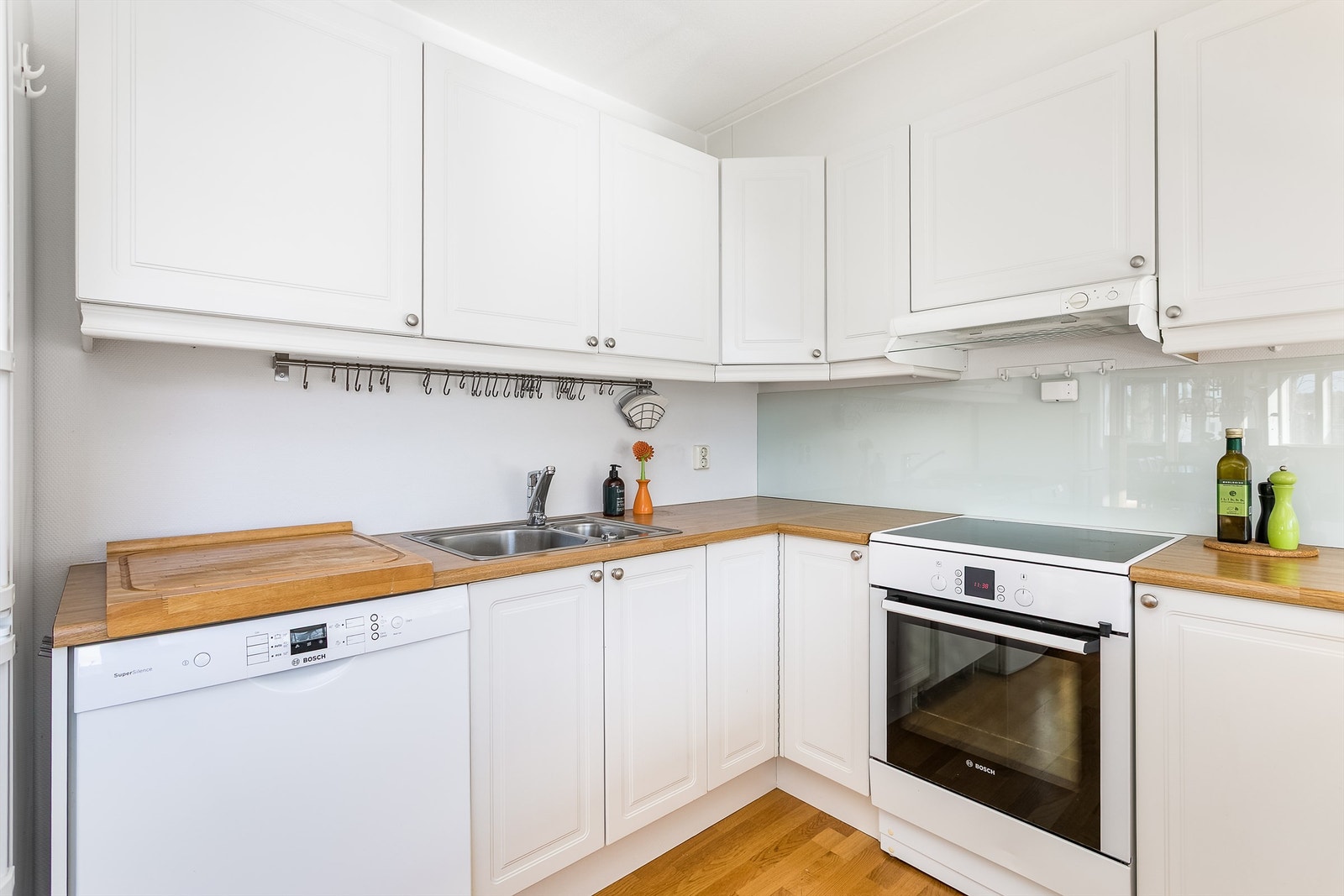 Mange oppbevaringsmuligheter kombinert med arbeidsflater rundt vask og kokesone gjør kjøkkenet praktisk i daglig bruk. Galleribilde