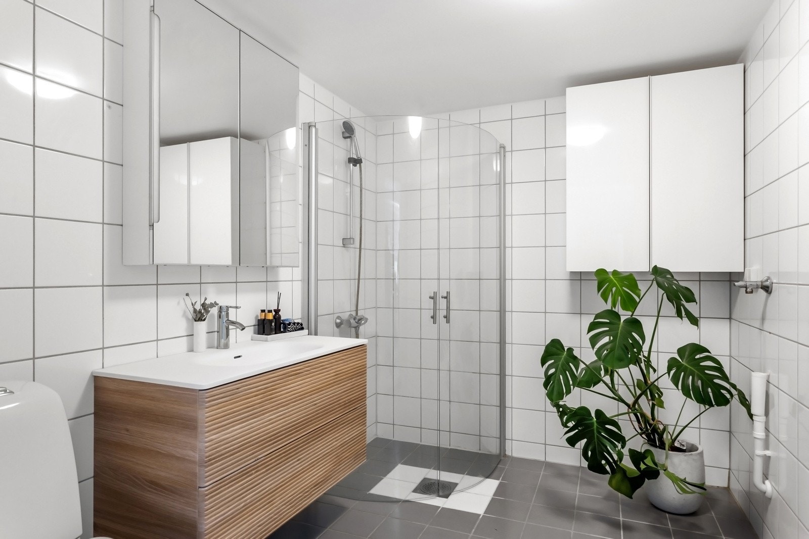 Pent, flislagt baderom med moderne baderomsinnredning. Galleribilde