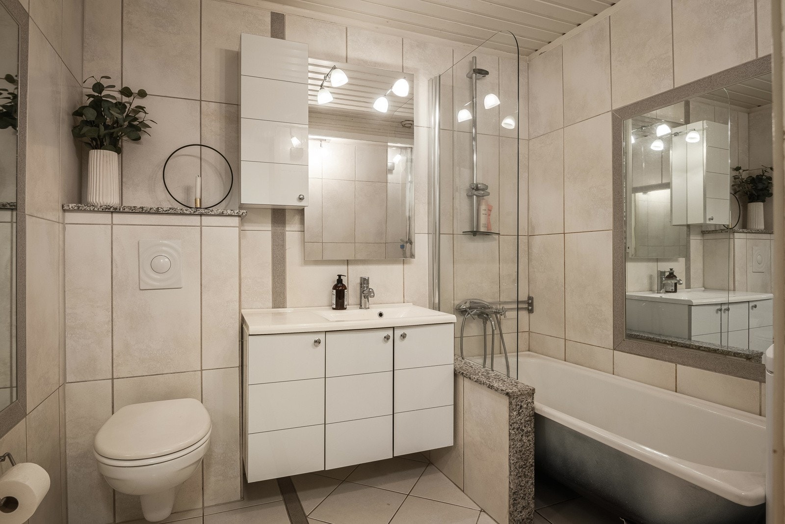 Baderommet i hybelen med vegghengt wc, servant, dusj i hjørne med innadslående dører. Galleribilde