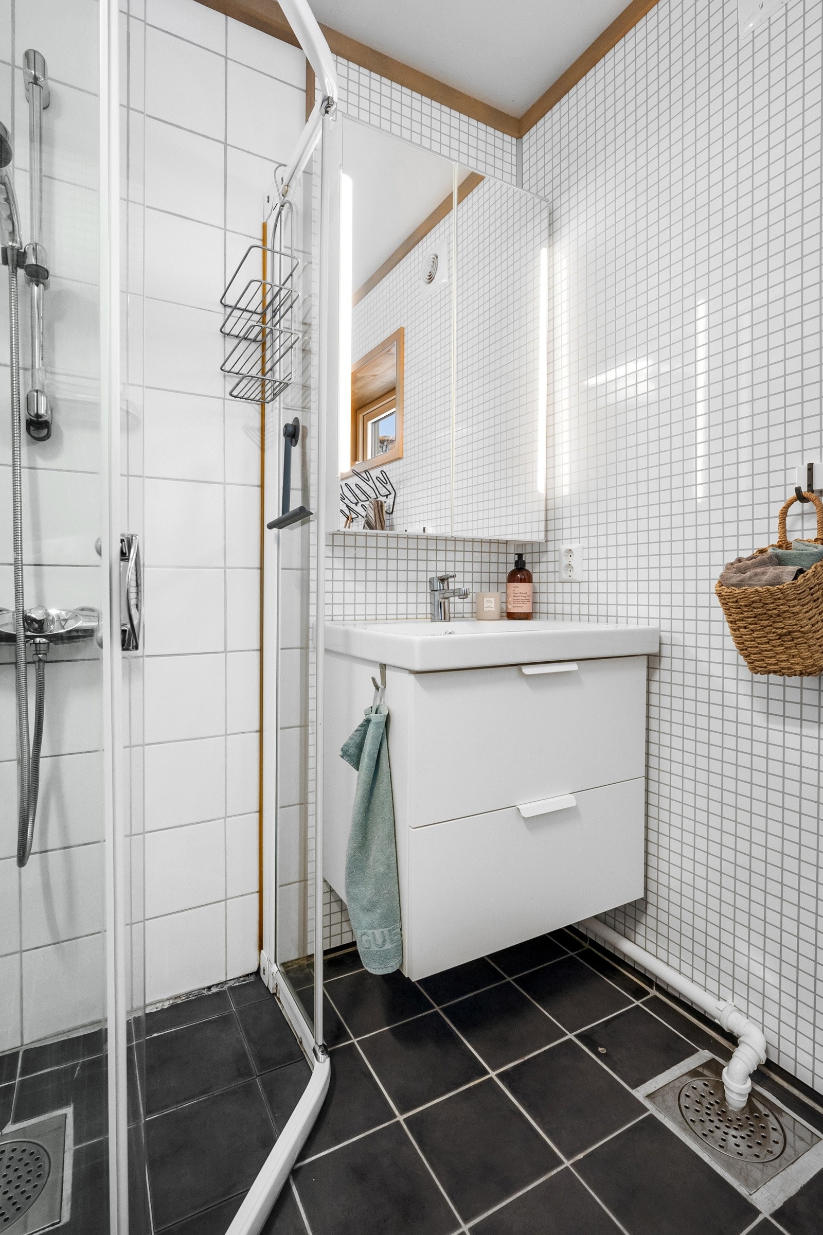 Lyse baderomsplater på vegger og godt med oppbevaringsplass i skap og baderomsmøblement. Galleribilde