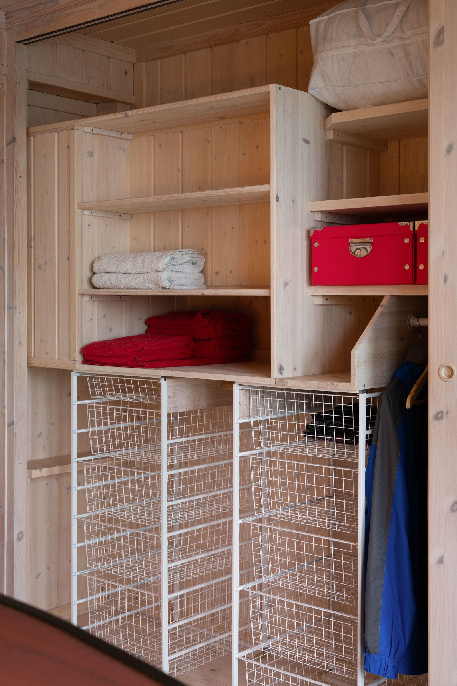 Langs den ene veggen har soverommet en stor og plassbygget skyvedørsgarderobe med hyller og kurver. Galleribilde