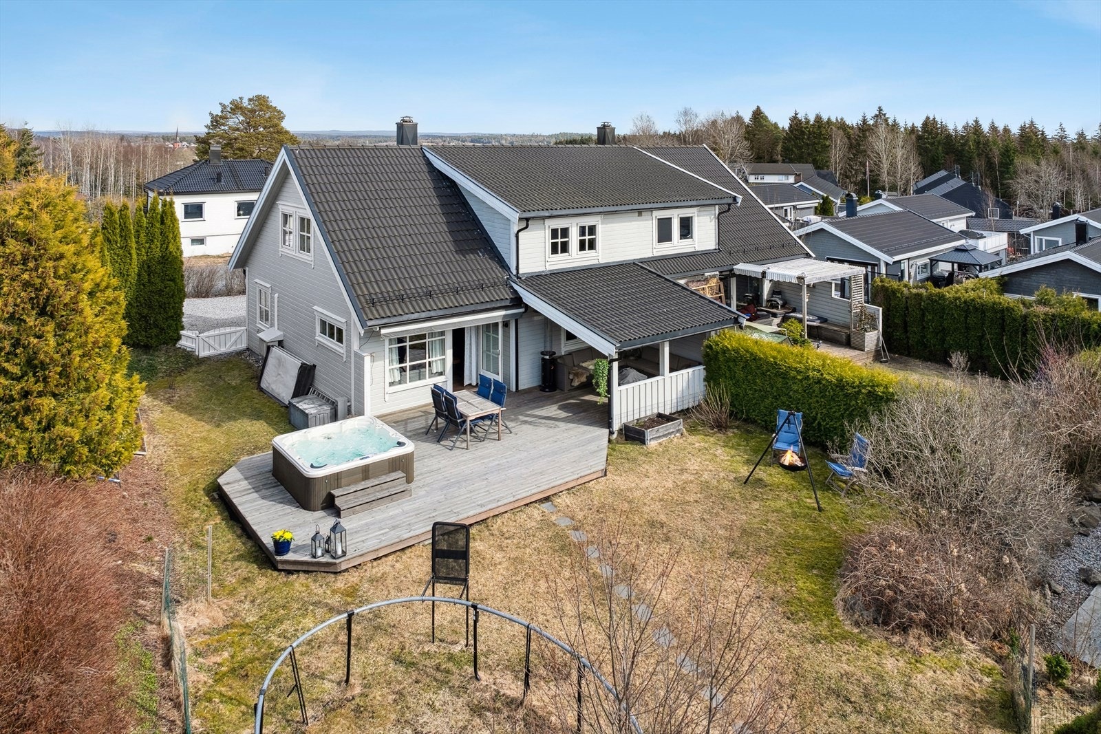 Det er en relativt flat tomt rundt boligen som er opparbeidet med gressplen, hekk, trær, diverse beplantninger, stor og delvis overbygd terrasse med jacuzzi. Galleribilde