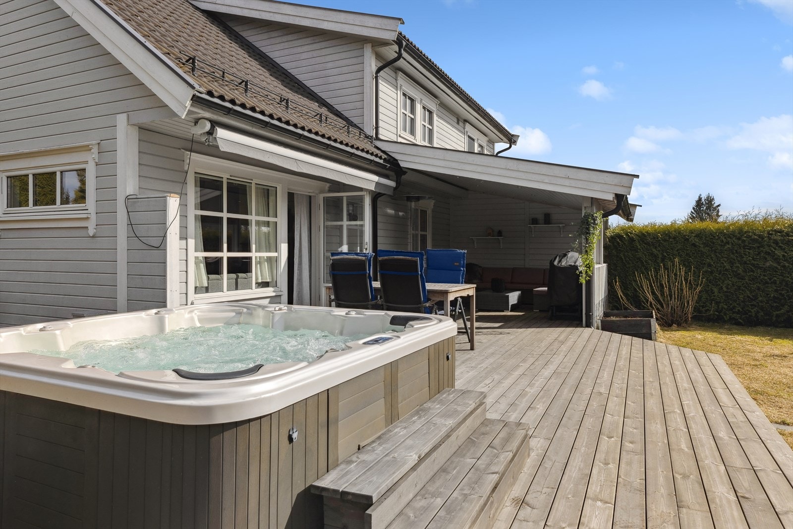 Fra stuen er det utgang til en usjenert og solrik hage med stor terrasse, overbygg og jacuzzi. Galleribilde