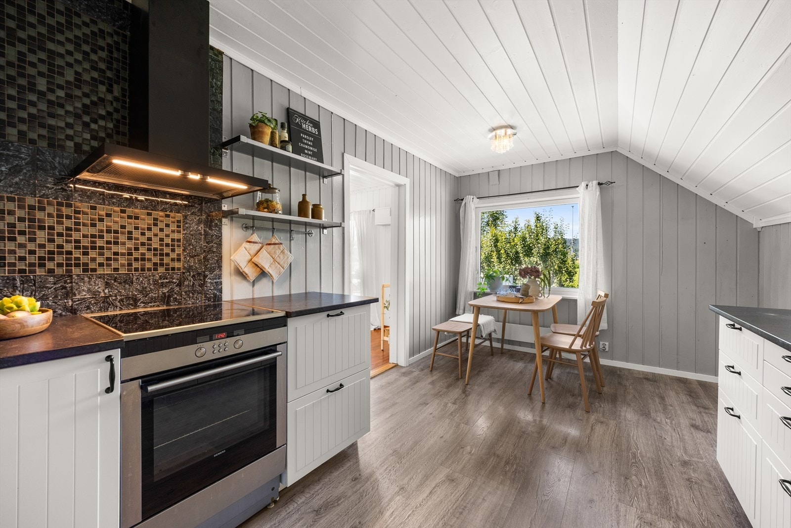 Kjøkkeninnredningen er fra IKEA med lyse fronter og laminat benkeplate Galleribilde