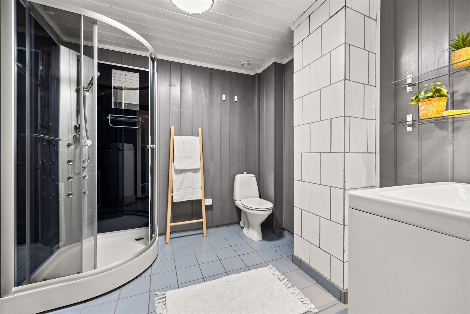 Innredningen er bestående av dusjkabinett, klosett og baderomsinnredning med speil og lys- spotter Galleribilde