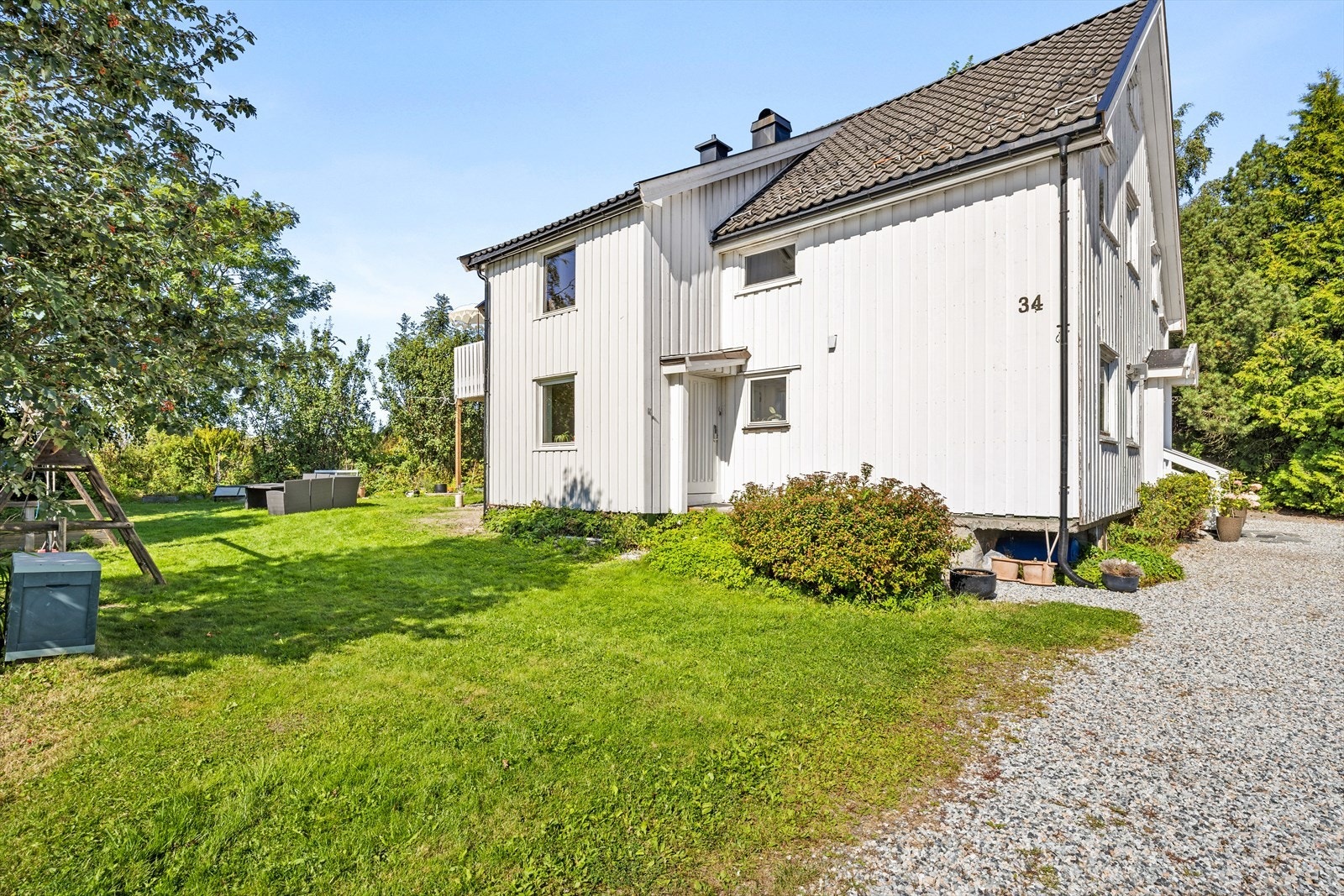 Inngang til høyre fra grusplassen tilhører denne leiligheten Galleribilde