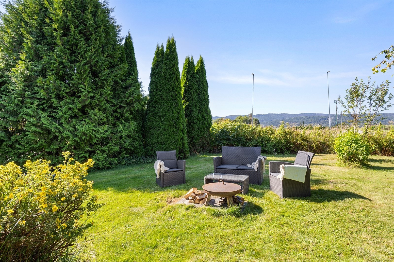 Hagen er pent opparbeidet med gressplen og beplantning. Det er opparbeidet en felles bålplass Galleribilde