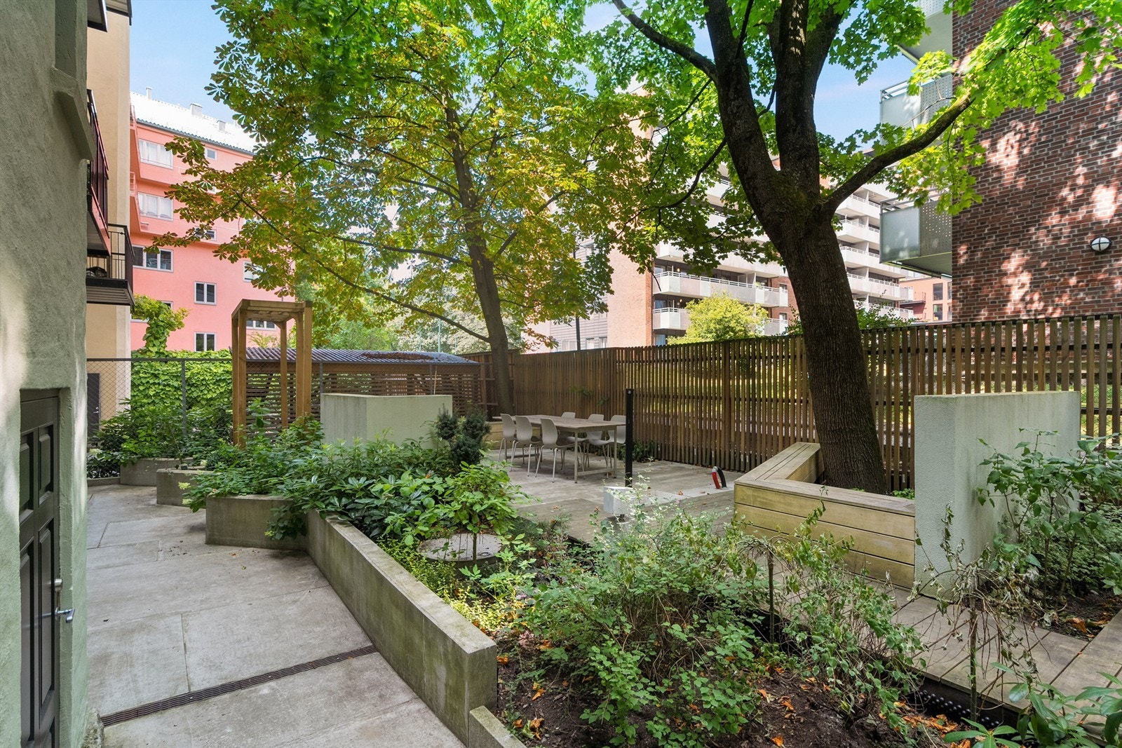 Bakgården har flere sosiale soner, et hyggelig sted å slå seg ned i skjermede omgivelser på varme sommerdager. Galleribilde