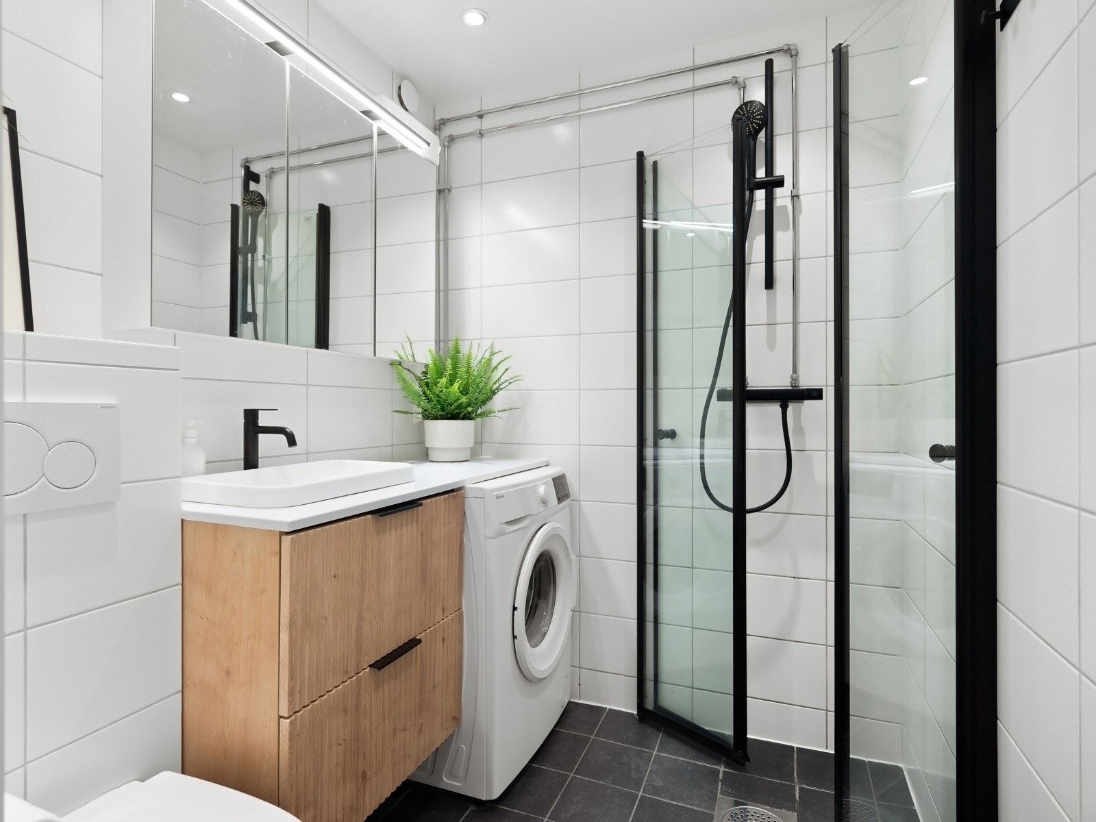 Leiligheten har et delikat flislagt bad fra 2015, med speil overskap og moderne innredning Galleribilde