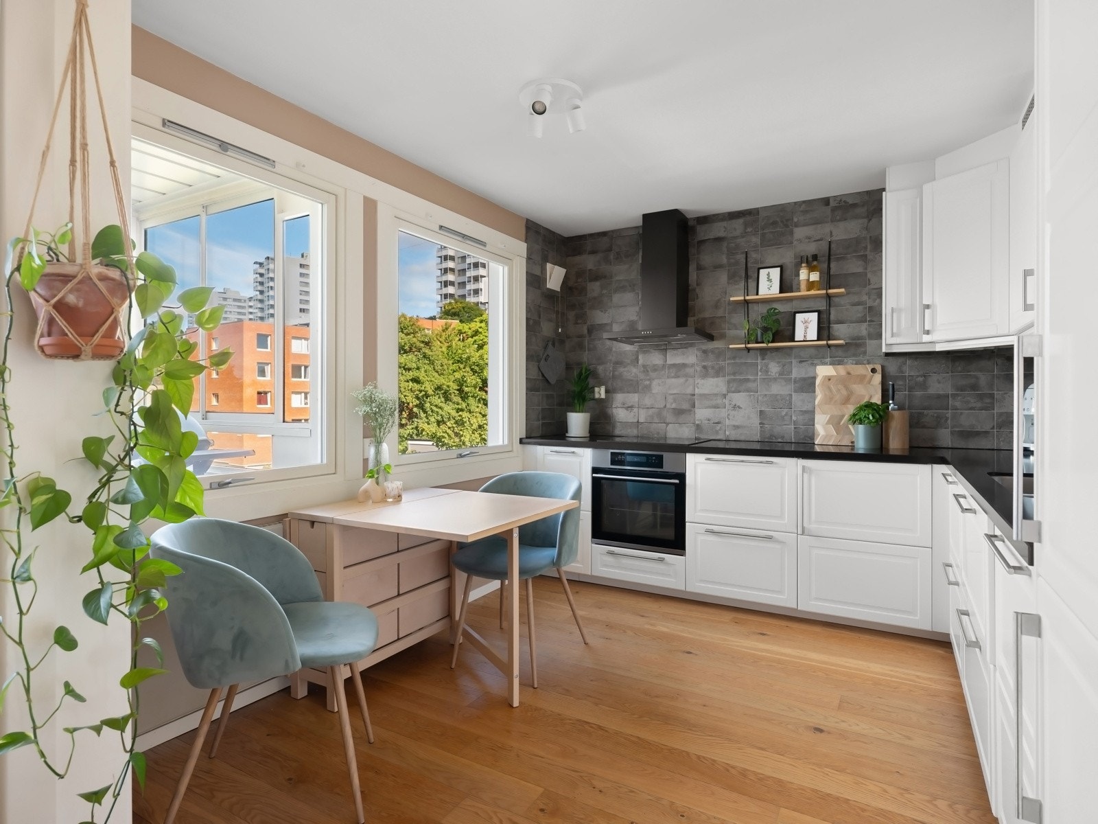 Kjøkkenet har en hvit kjøkkeninnredning fra IKEA med profilerte fronter og benkeplate i Kvarts kompositt fra 2018 Galleribilde