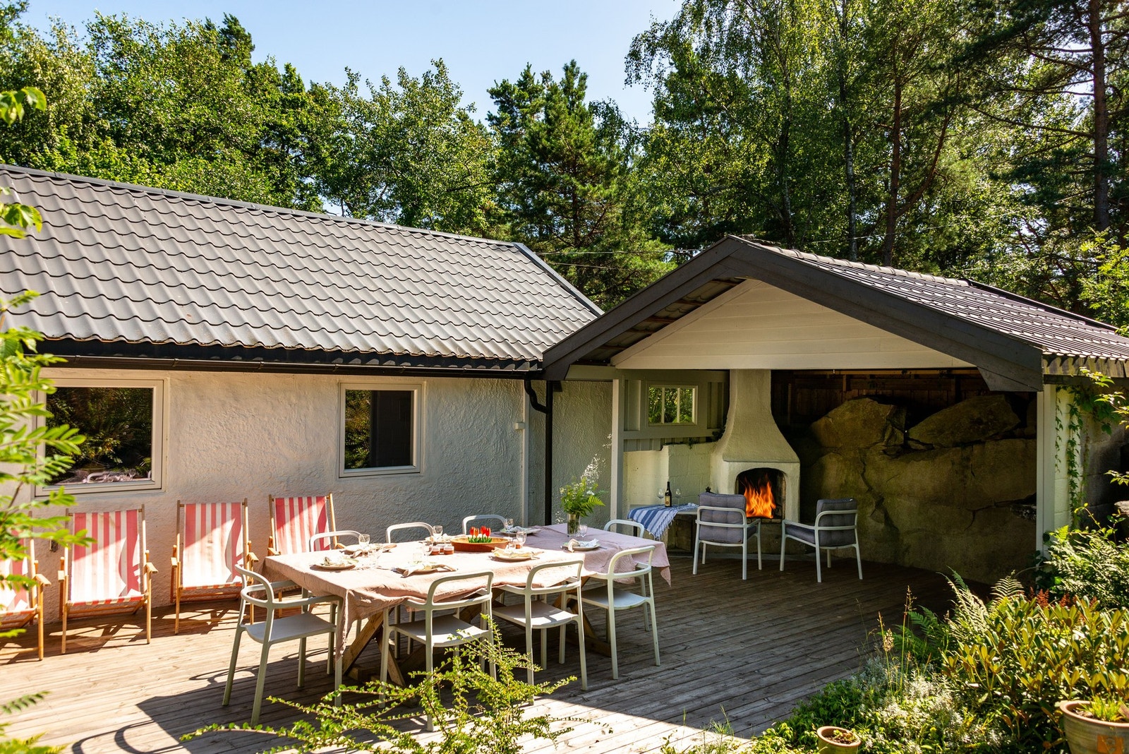 Hytta, pergola og vegetasjon frembringer en solrik, privat uteplass Galleribilde