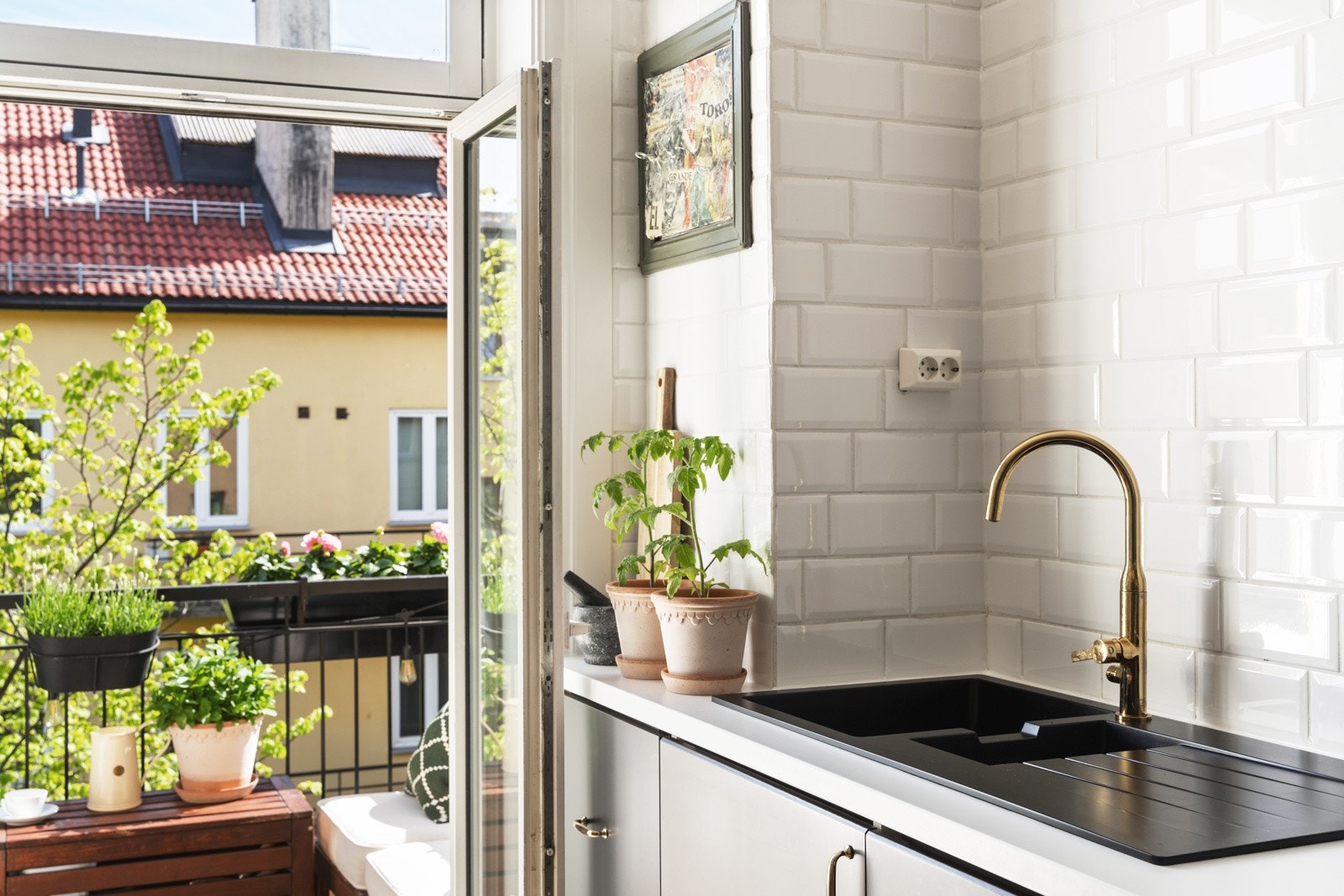 Den solfylte balkongen vender mot indre bakgård og blir en forlengelse av kjøkkenet på sommerhalvåret. Galleribilde