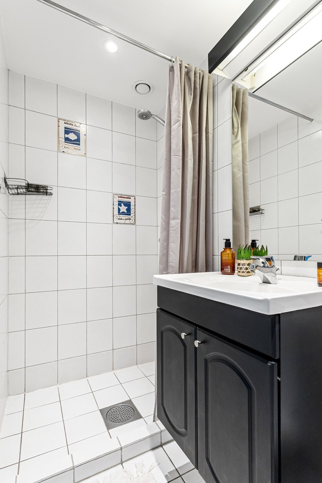 Badet har dusjsone, servant med innredning og toalett Galleribilde