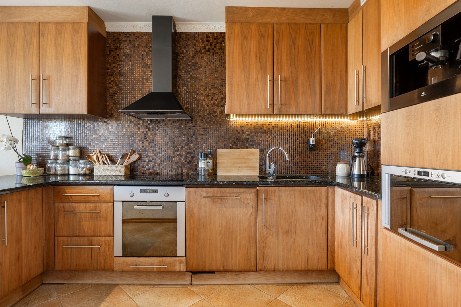 Kjøkkeninnredningen har slette fronter og benkeplate av stein med underlimt oppvaskkum. Galleribilde