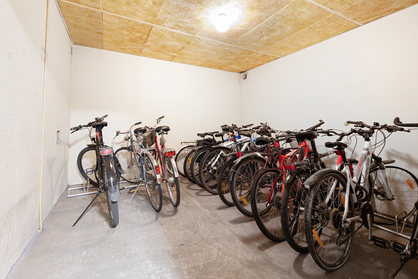 Det er felles sykkelparkering i en bod i bygningen. Galleribilde