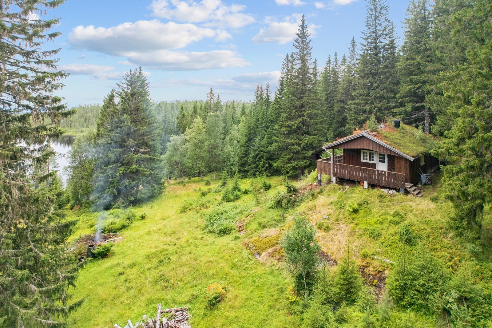 Hytta ligger fint til i terrenget med utsikt over vannet. Galleribilde