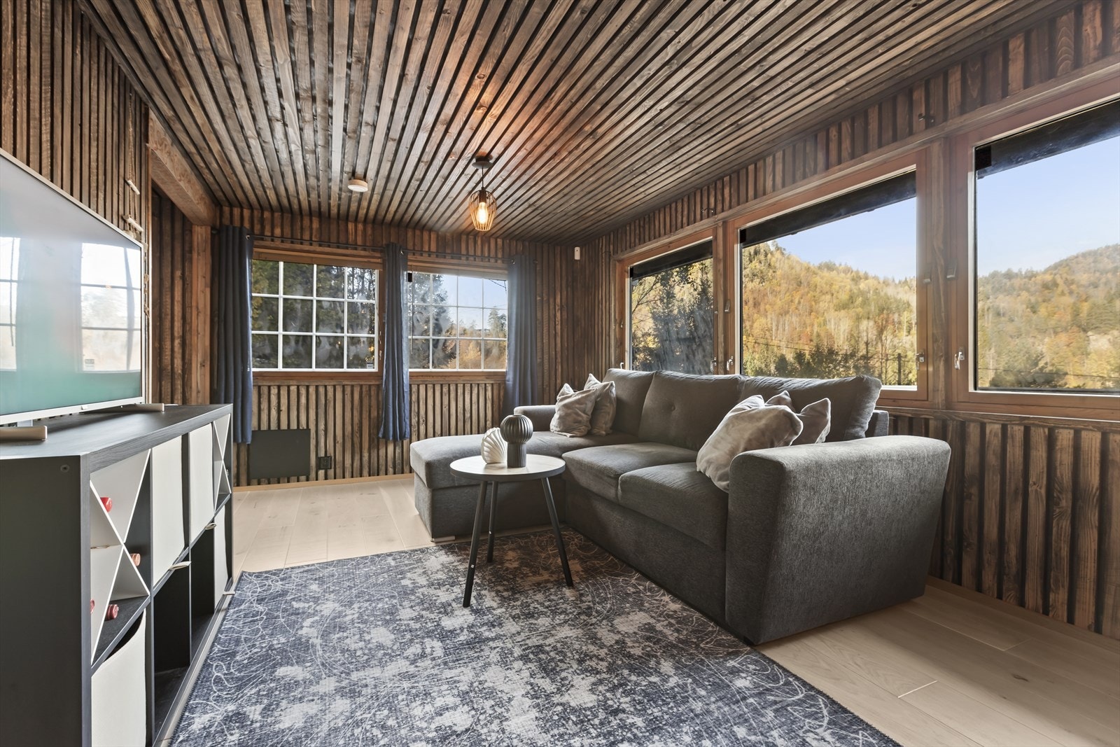 Rikelig plass til stue med sofa, salongbord og TV-seksjon. Galleribilde