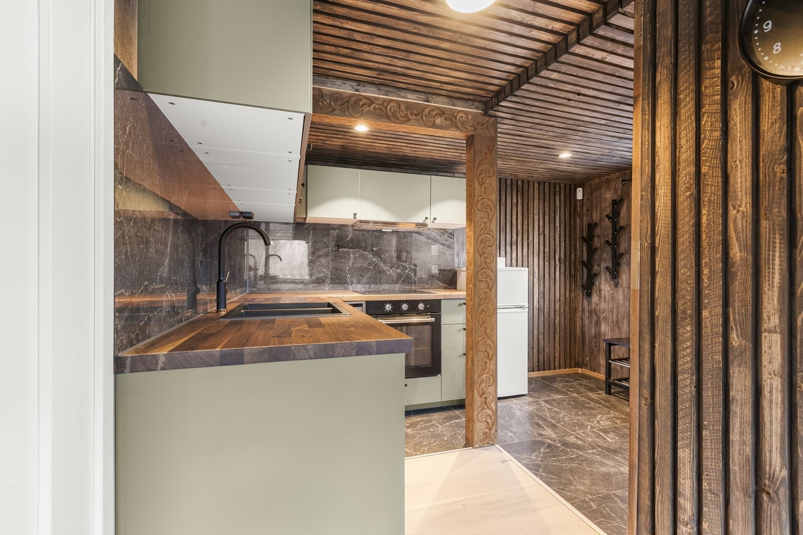 Pent kjøkken i delvis åpen løsning med stuen. Galleribilde