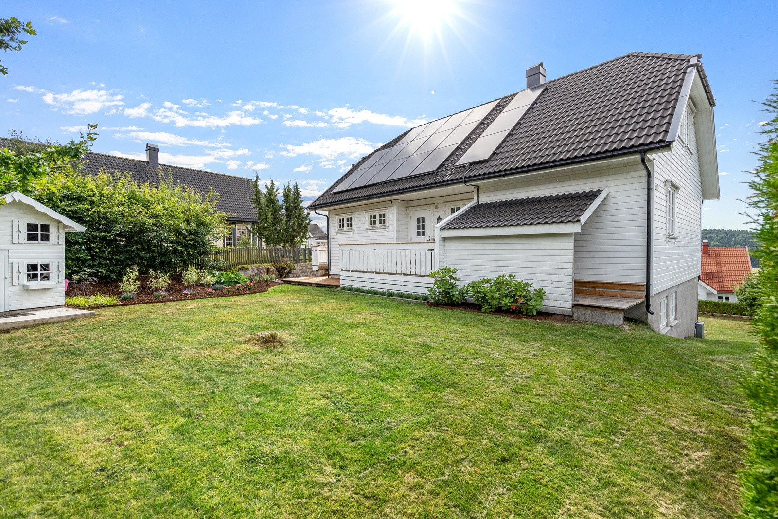Solcellepanelet gjør strømregningene litt rimeligere! Fin plen og blomsterbed i hagen. Galleribilde