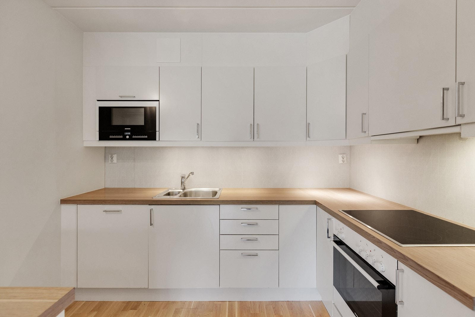 Kjøkkenet har en moderne innredning fra Sigdal, med glatte fronter som gir et stilrent og tidløst uttrykk. Galleribilde