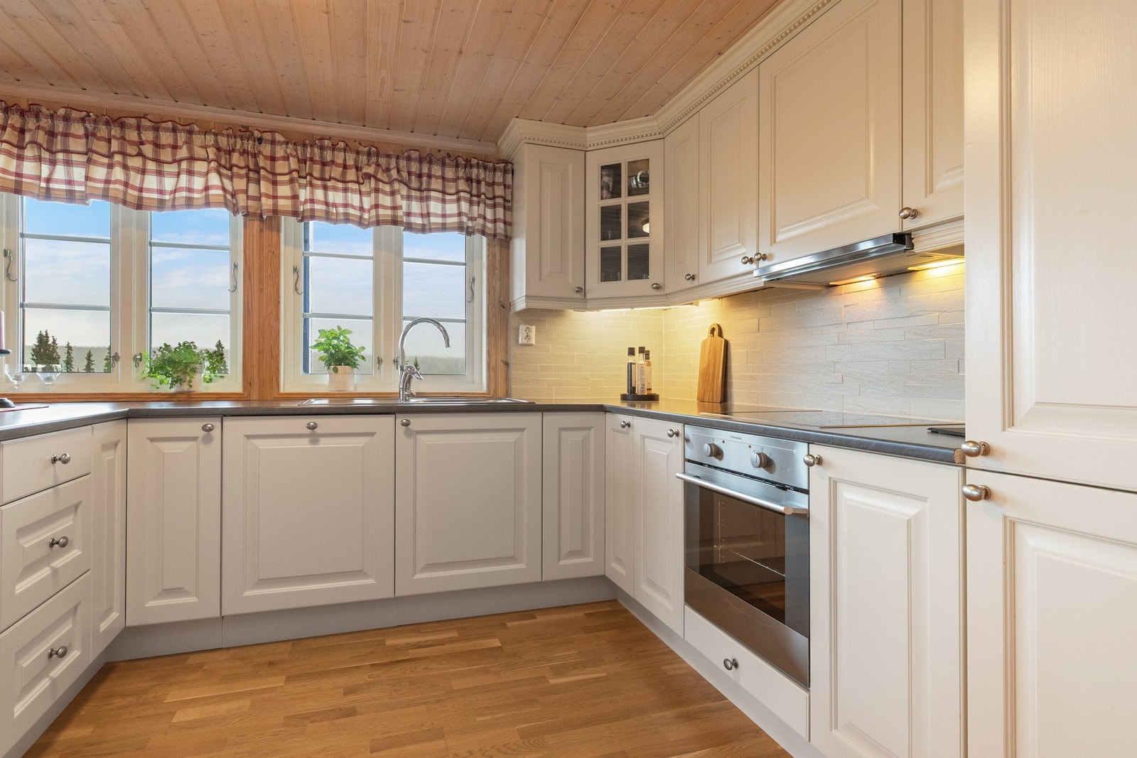 Lys kjøkkeninnredning i heltre med god benk- og skapplass Galleribilde