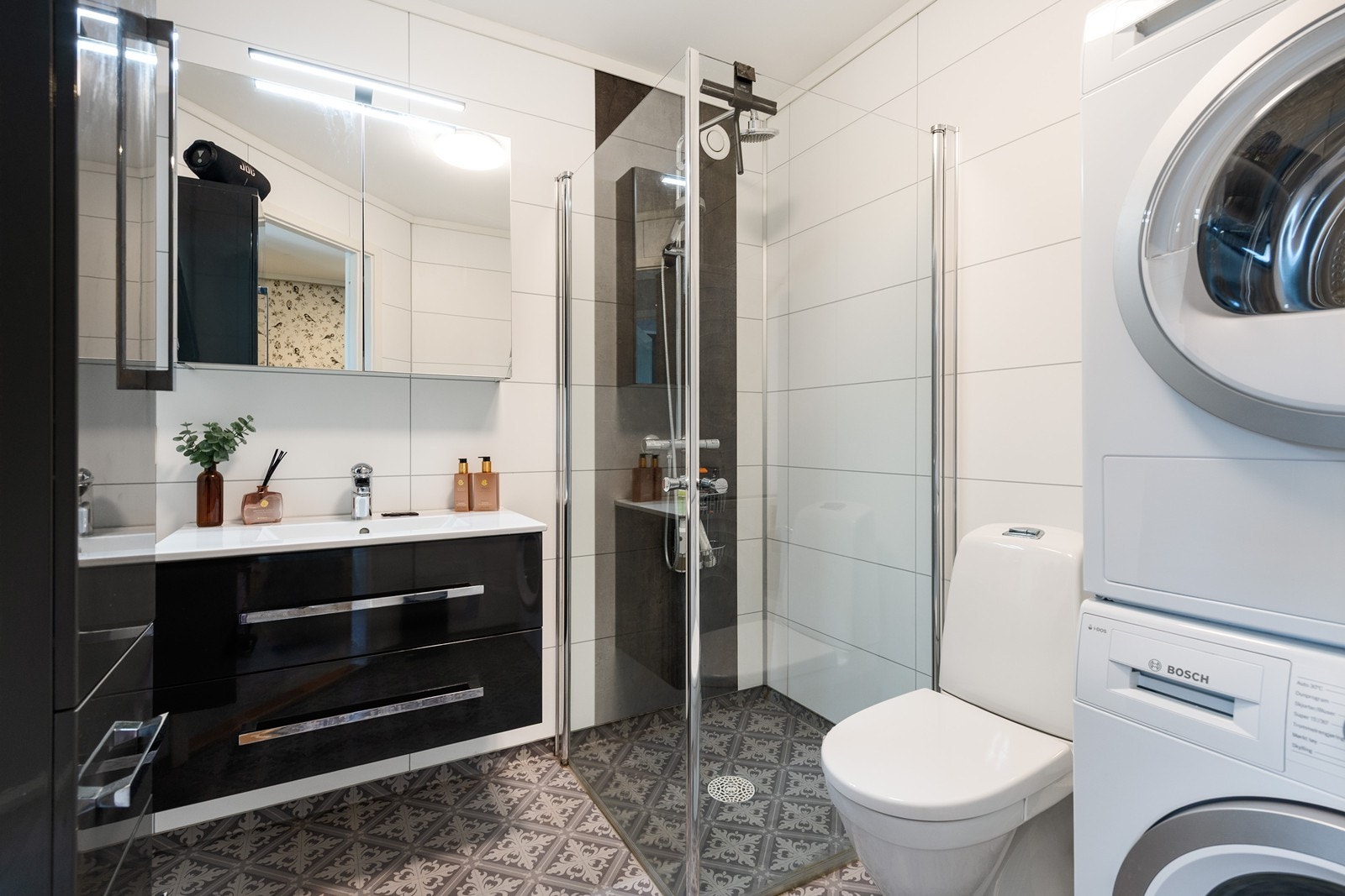 Badet har vaskeservant i innredning, gulvmontert toalett , dusjhjørne
og opplegg for vaskemaskin. Galleribilde