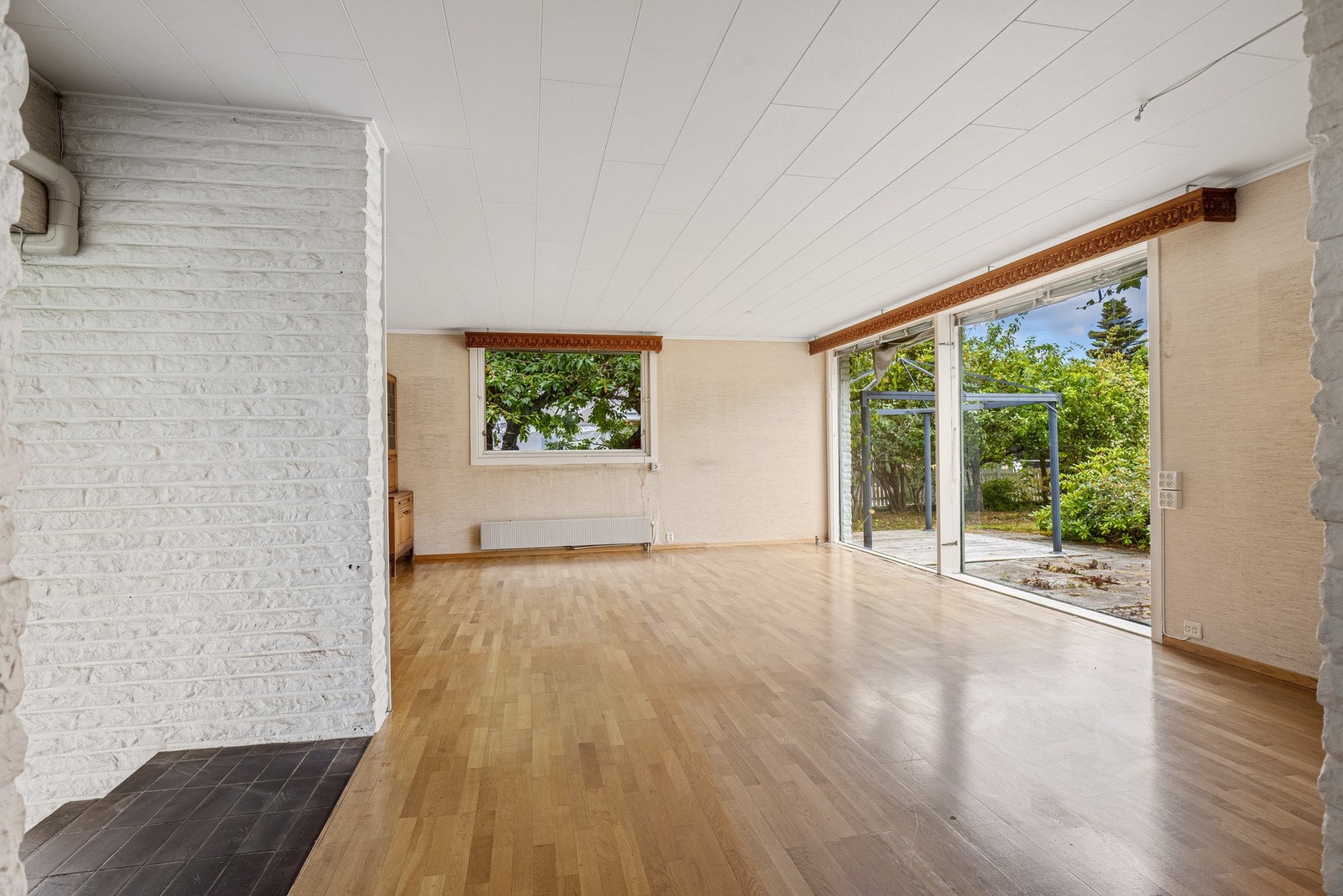 Boligen er gjennomgående bevisst bruk av vinduer ned til gulvet som knytter innendørs rom sammen med hagen