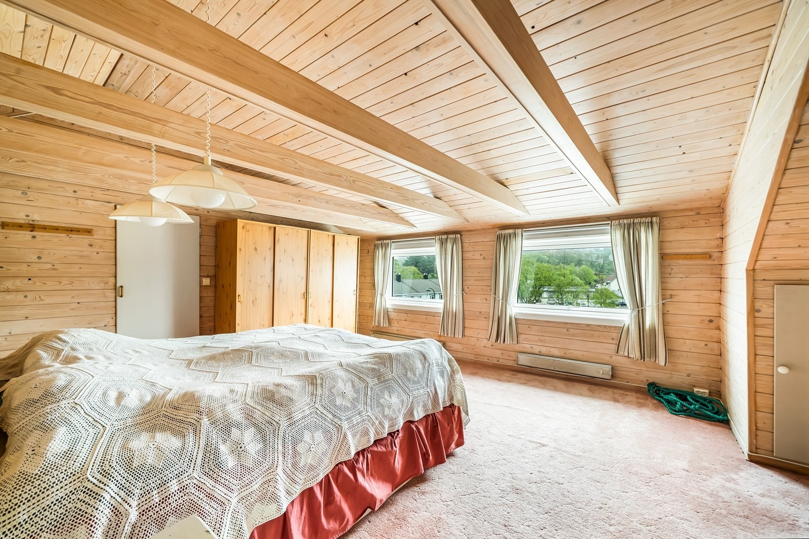 Soverom på loftet med rom for lagring i hver side av rommet. Galleribilde