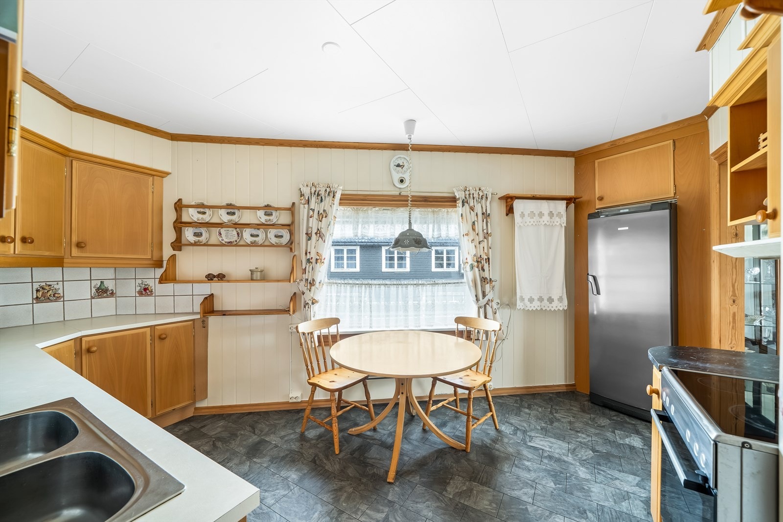 Pent kjøkken med innredning fra Hamran kjøkken. Enkeltstående hvitevarer medfølger. Plass på kjøkkenet til spisemøblement. Galleribilde