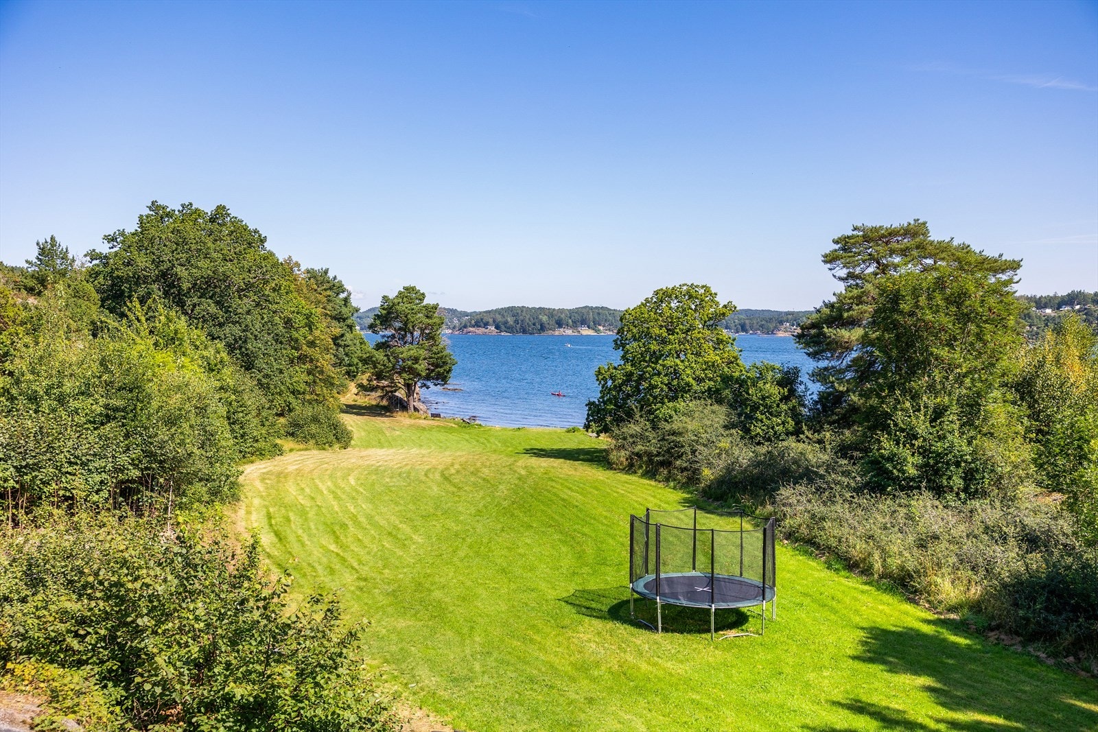 Stor gressplen som leder ned til vannet. Galleribilde