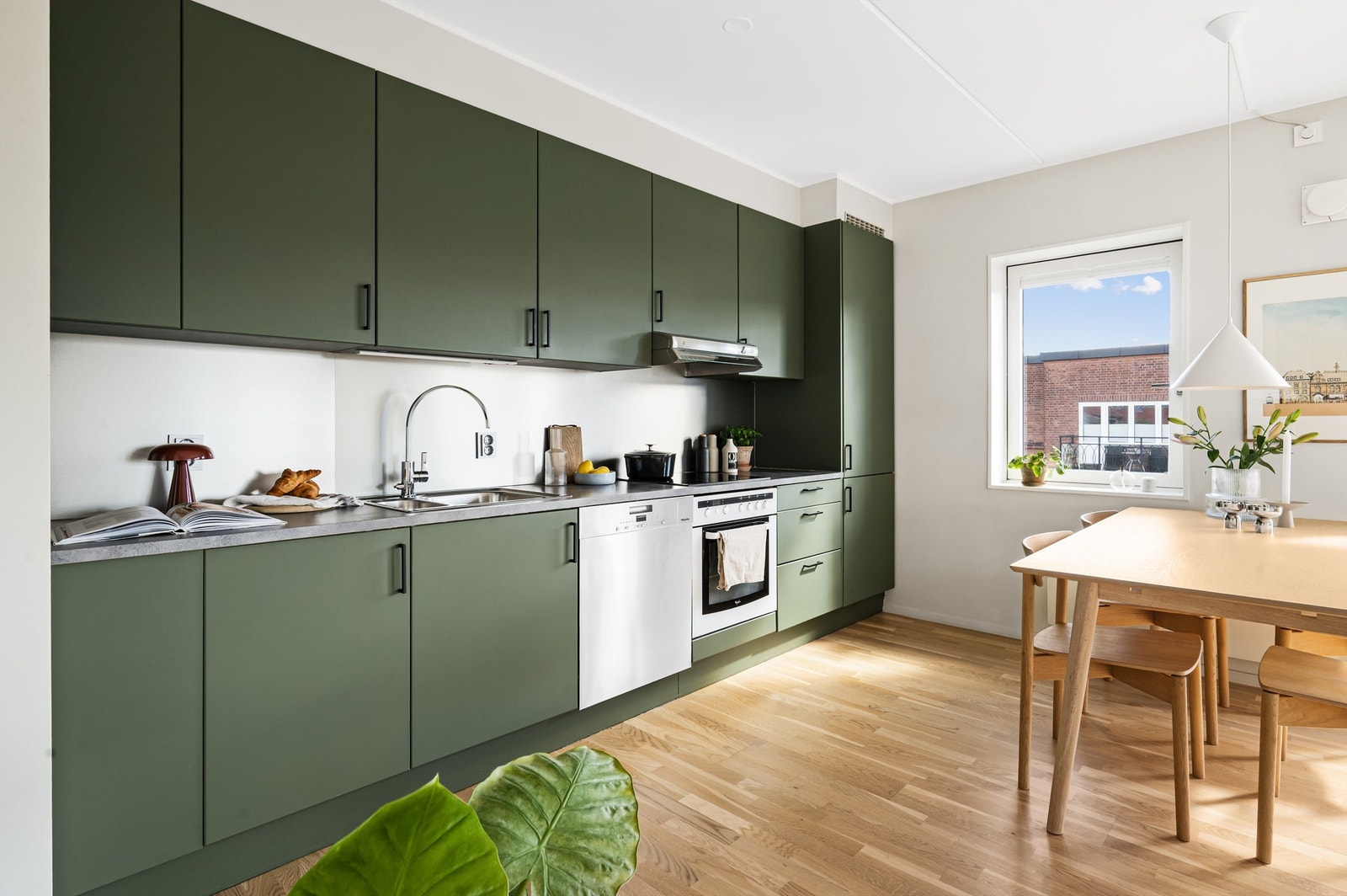 Kjøkkeninnredningen er av glatte fronter og benkeplate i laminat med nedfelt vaskekum. Hvitevarene er sømløst integrert i innredningen og består av kjøl-/fryseskap, platetopp og stekeovn. Galleribilde