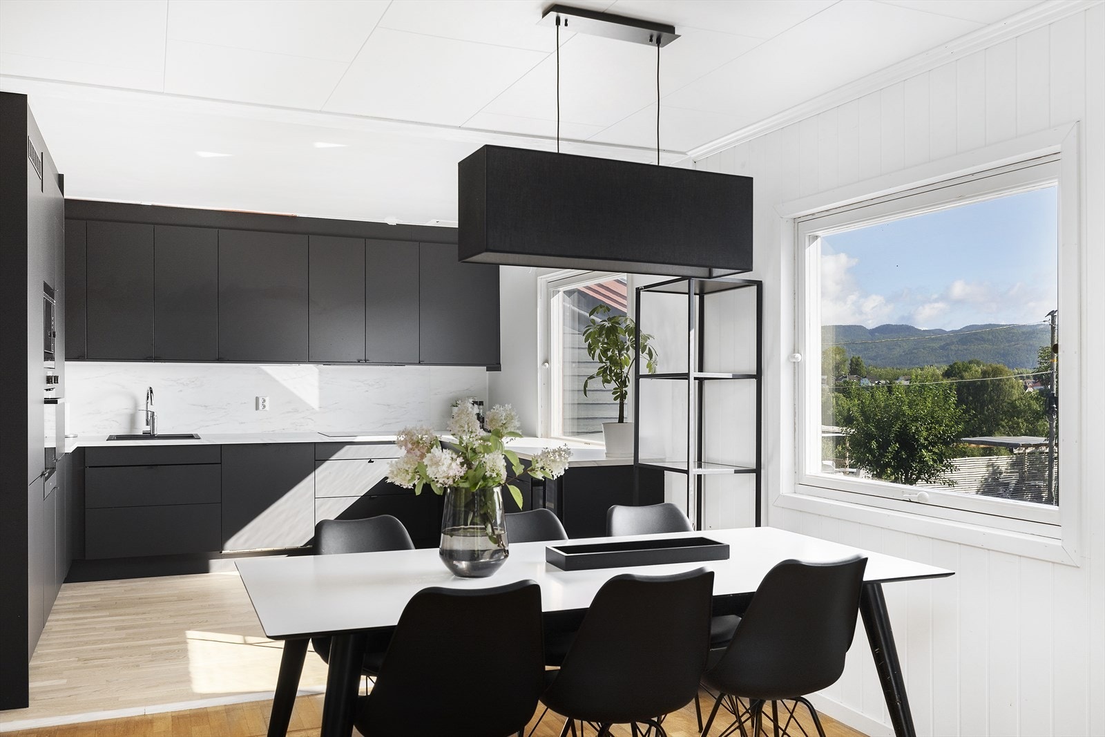 Nytt moderne kjøkken (2024), med slette sorte fronter og overskap til tak. Galleribilde