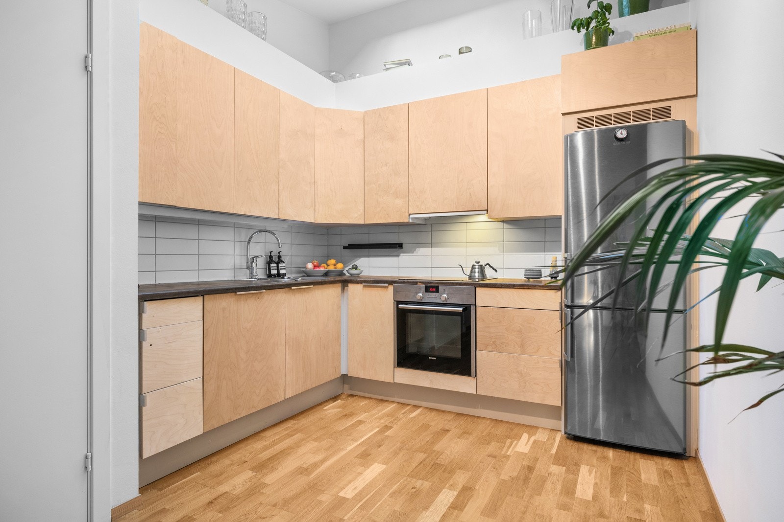 Fin kjøkkeninnredning med glatte fronter av bjørk kryssfinér. Galleribilde