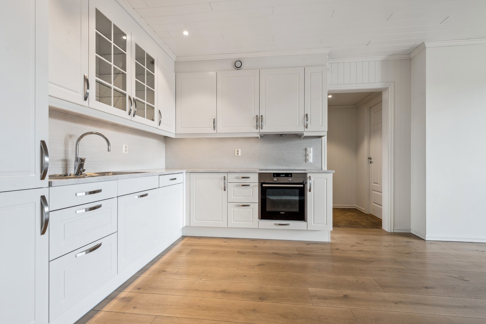 Kjøkkenet har integrerte hvitevarer og nedfelt induskjonstopp Galleribilde