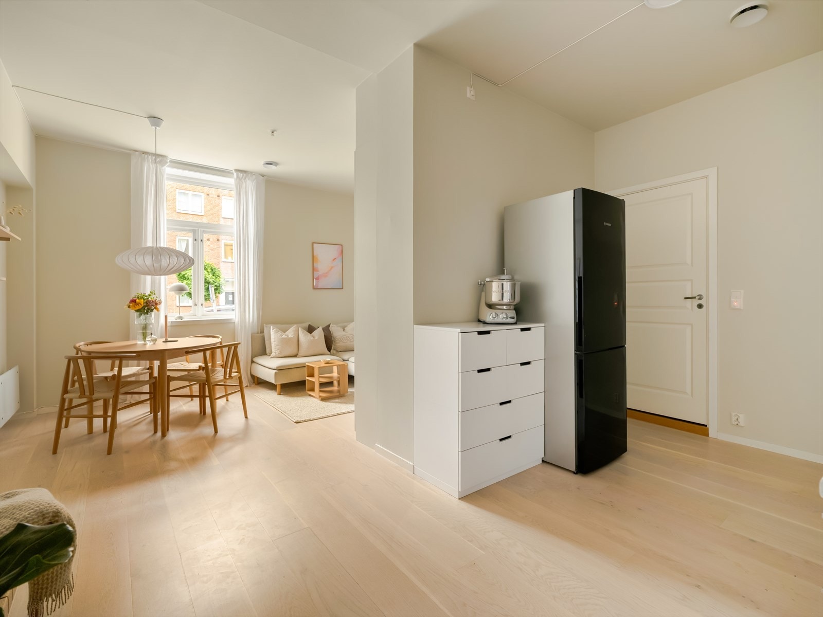 Åpen løsning mellom kjøkken og stue gir et sosialt og funksjonelt oppholdsrom, perfekt for både hverdagsliv og underholdning. Galleribilde