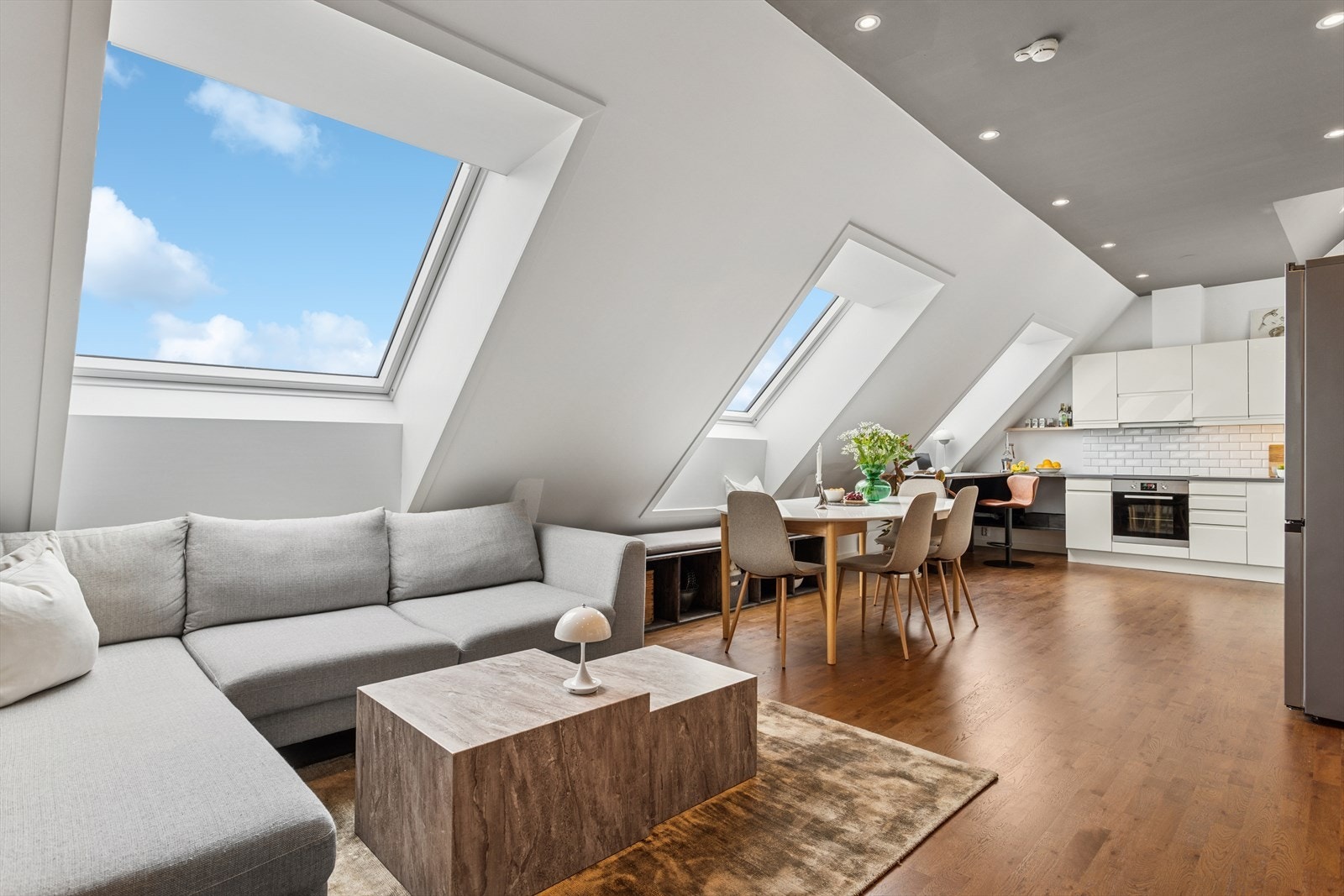 Leiligheten har en innbydende og åpen stue- og kjøkkenløsning med god plass til både sofa, TV-seksjon og spisebord Galleribilde