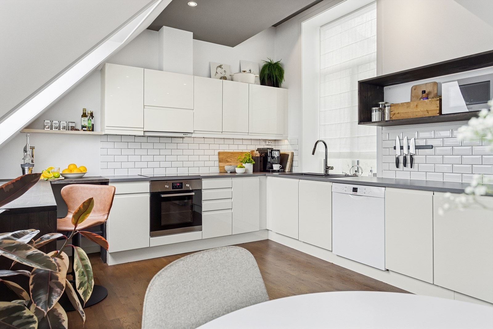 Benkeplate er i laminat. Det er godt med arbeidsflate, og praktiske fliser over benkeplate Galleribilde