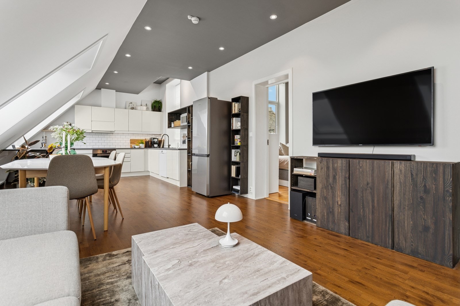 Den åpne planløsningen gir en luftig romfølelse og skaper en naturlig flyt mellom sonene, noe som gjør det enkelt å innrede både for hverdagsliv og sosiale sammenkomster Galleribilde