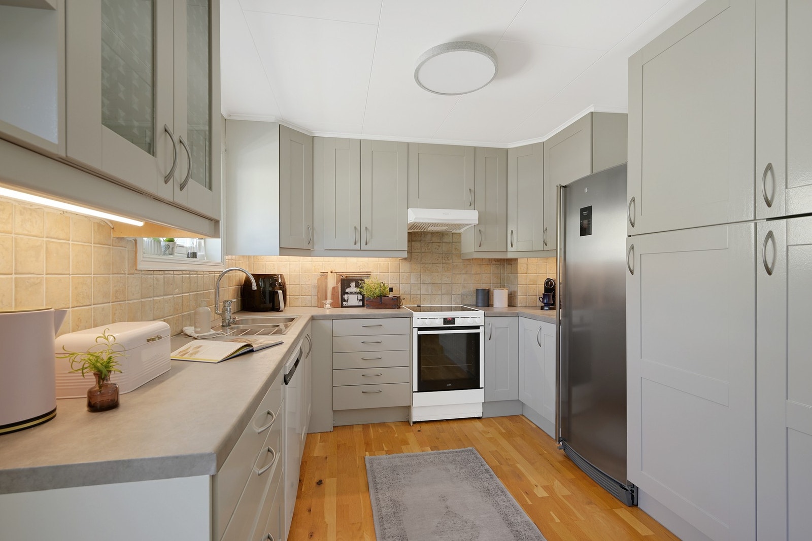 Kjøkkenet har malte profilerte fronter og benkeplate i laminat. Galleribilde