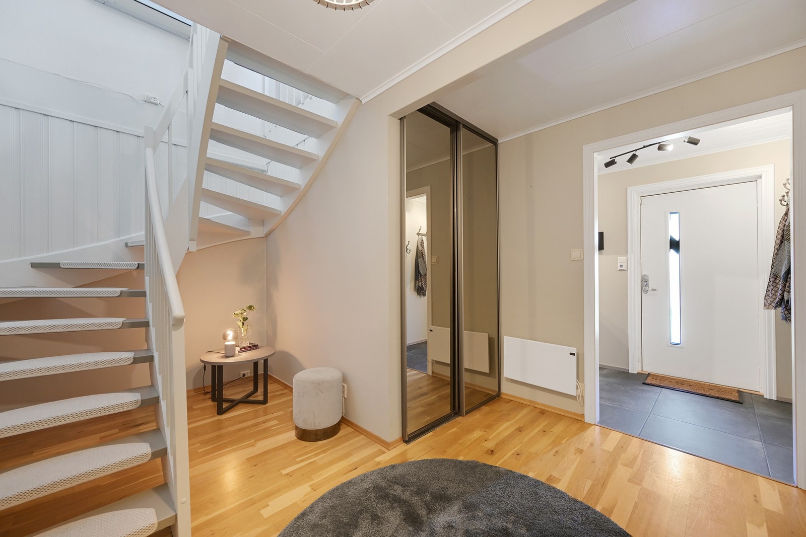 I fortsetter rundturen ned trappen og ser her den romslige hallen med skyvedørsgarderobe. Galleribilde