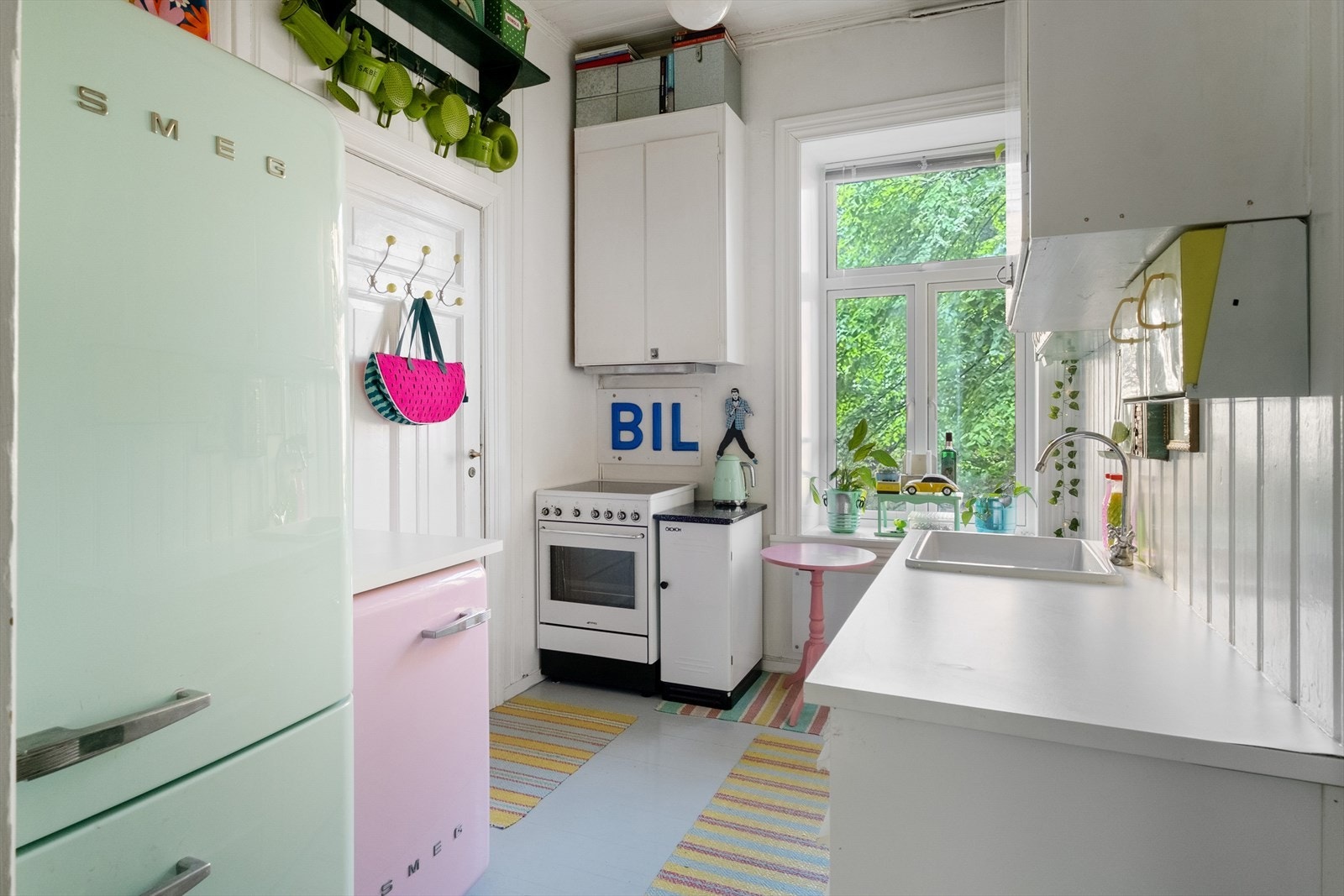 Eldre kjøkkeninnredning med heltre fronter og laminat benkeplate med nedfelt vask. Avtrekk over kokeplass. Galleribilde