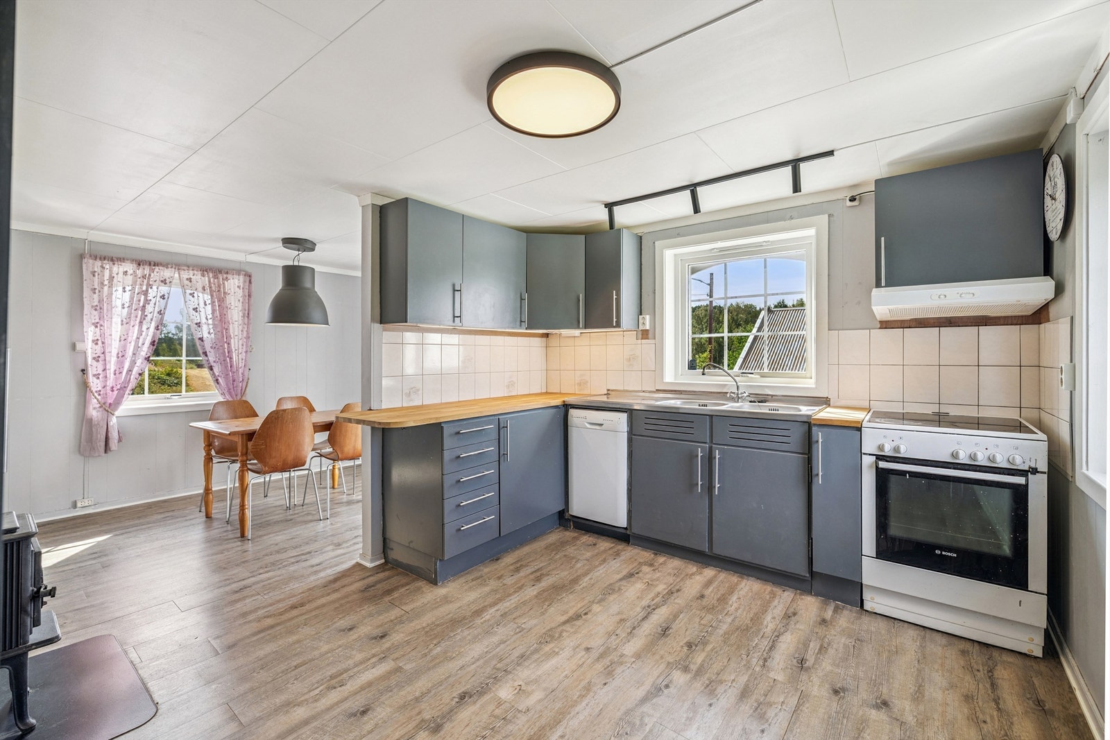 Romslig kjøkken med eldre innredning som har plass til frittstående hvitevarer. Opplegg til oppvaskmaskin. Galleribilde