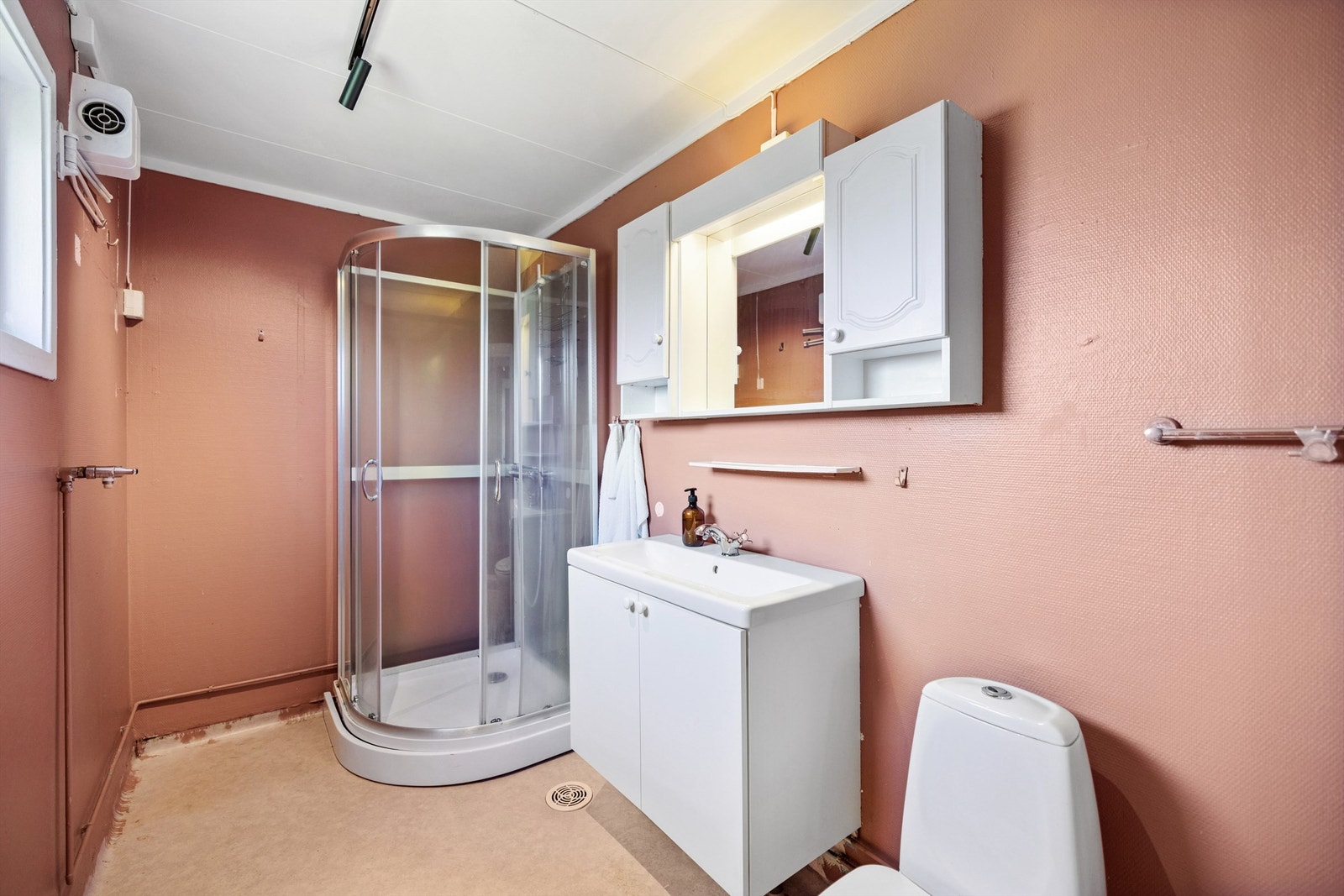 Badet er utstyrt med servantskap, toalett og opplegg for vaskemaskin. Elektriske varmekabler i gulvet. Galleribilde