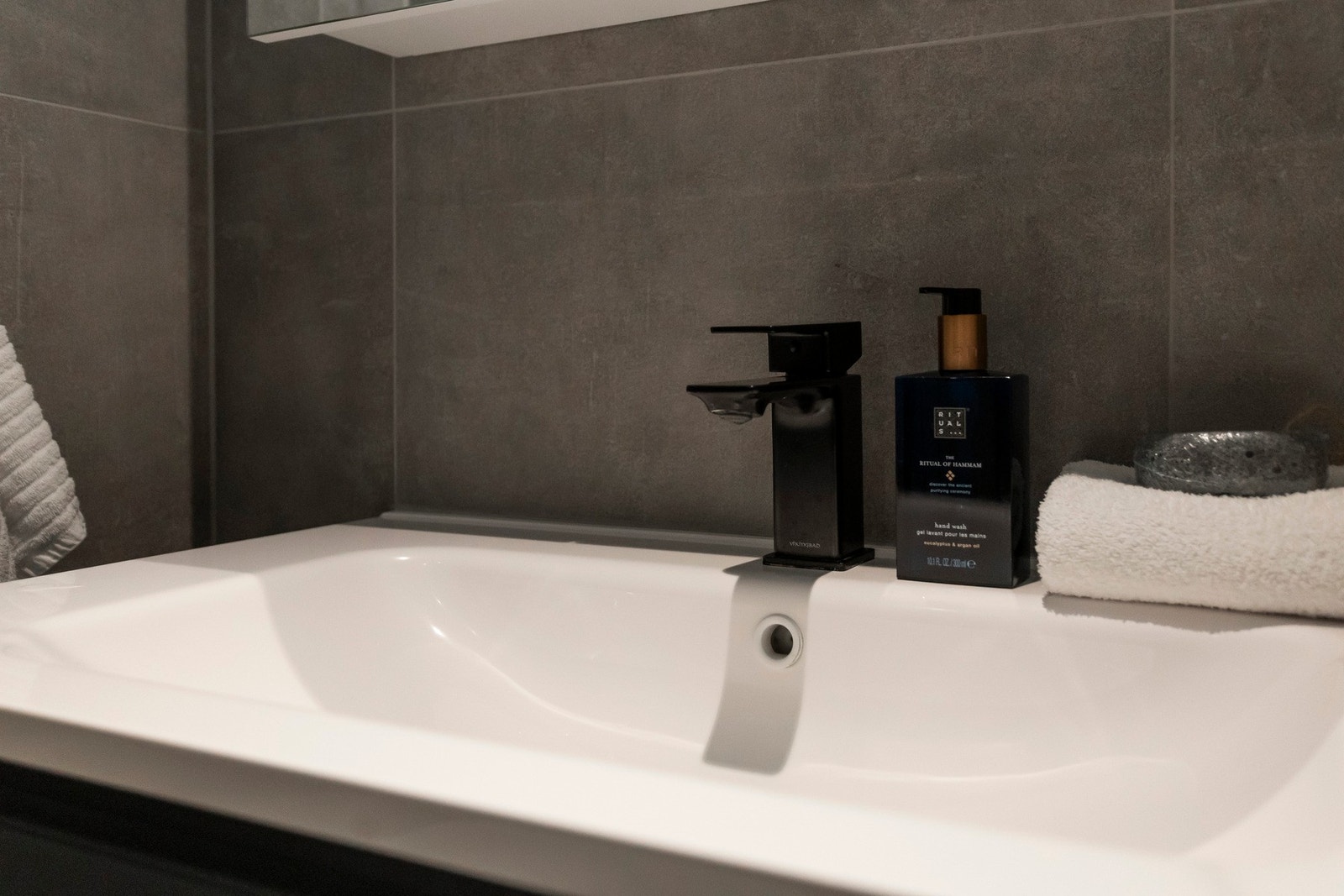 Badet har vegghengt servantinnredning med skuffer og ovenpåliggende servant, samt speilskap med integrert belysning på vegg over servant. Galleribilde