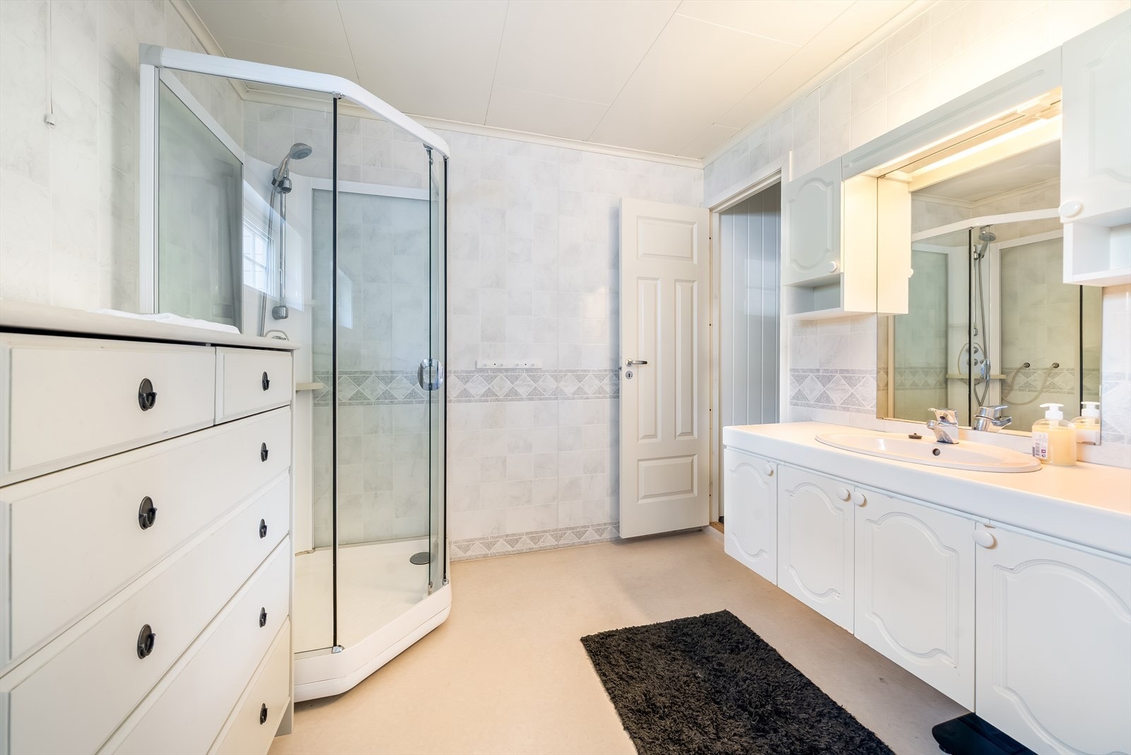 Lyst og romslig baderom med moderne dusjløsning og praktisk innredning. Galleribilde